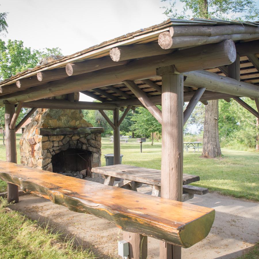 A log picnic shelter with a stone fireplace at Lake Chelan State Park.