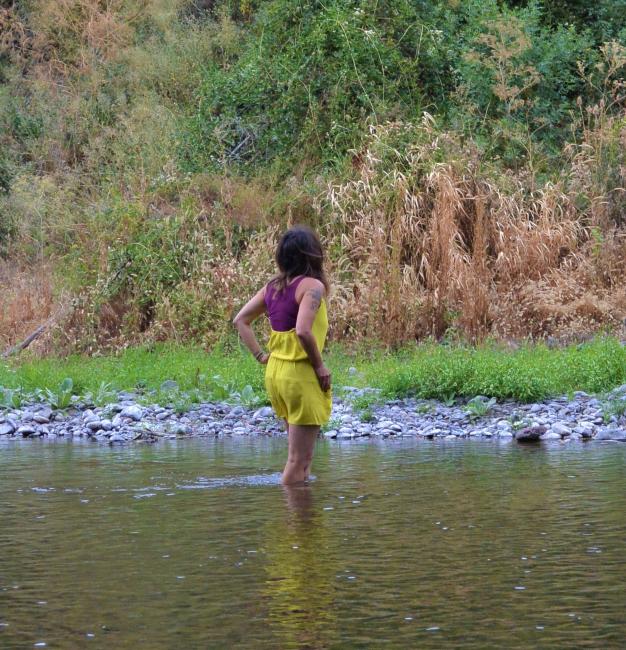 Woman stands in a river looking at nature