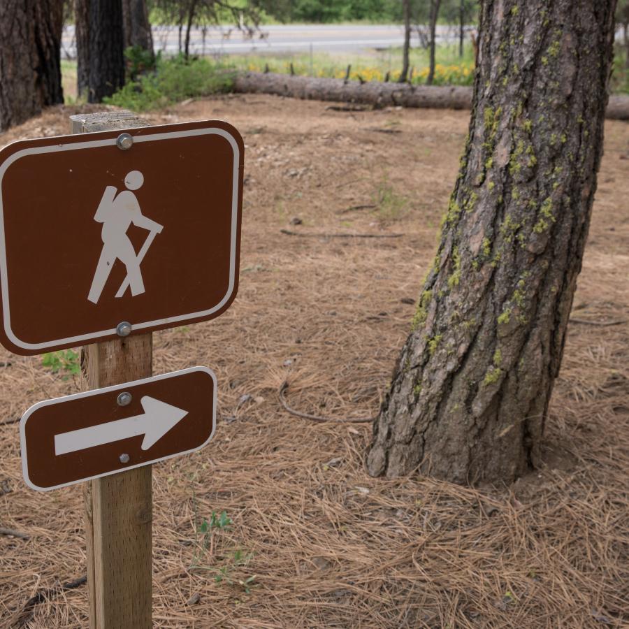 Hiking sign with arrow pointing the direction to the trailhead