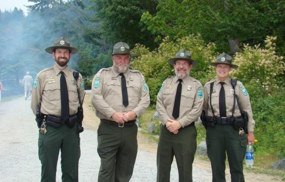 Four park rangers in front of trees